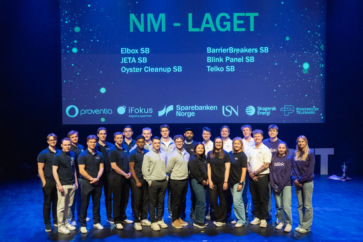 Gruppe deltakere står på en opplyst scene foran en stor skjerm med teksten «NM-laget» og flere logoer.